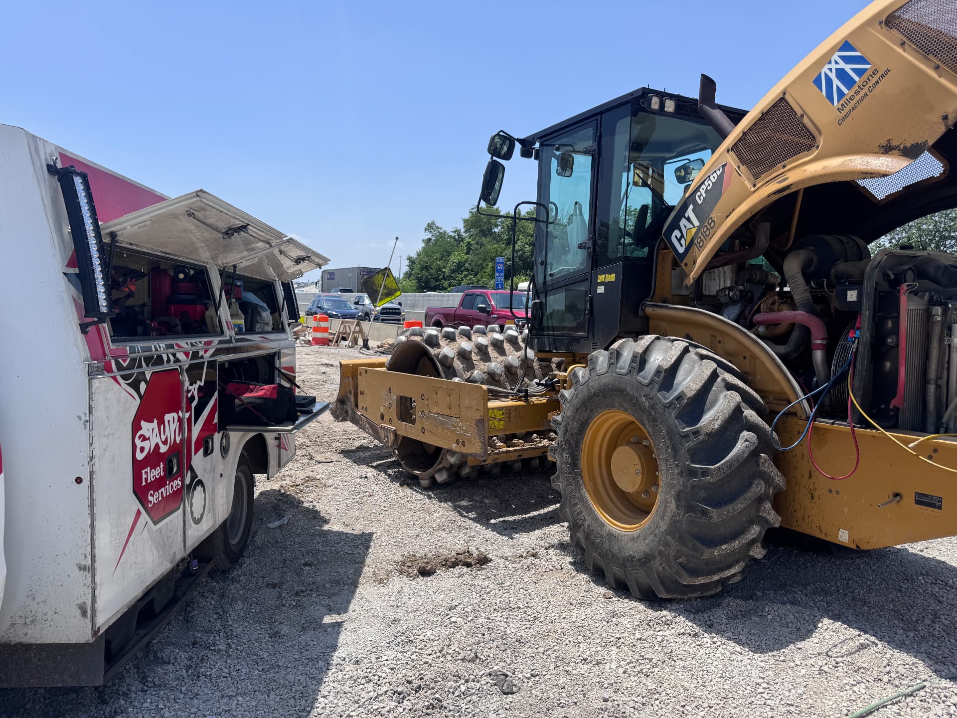 StayPut service truck next to a CAT compactor with the engine hood open